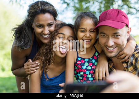 Playful family taking selfie with camera phone Stock Photo