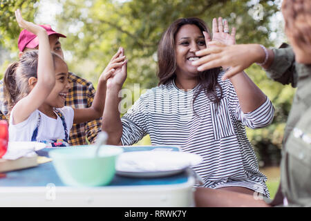Happy, playful family at campsite table Stock Photo