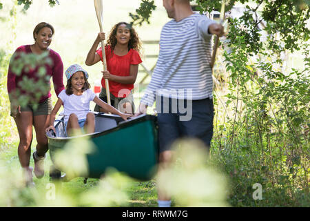 Family pulling canoe in woods Stock Photo