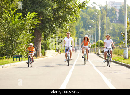 Happy family on bicycles for a walk in park. Stock Photo