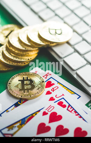 Red glass playing dices and bitcoins on green table. Stock Photo