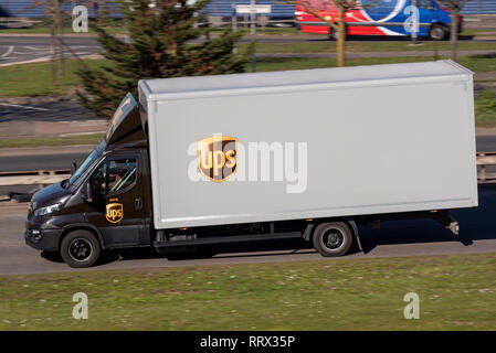 UPS box van truck, lorry, vehicle driving on the road in the UK. United Parcel Service mail, package service Stock Photo