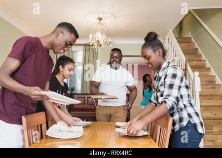Teenage siblings setting table