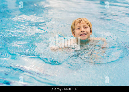 Close up of young boy swimming in pool