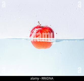 Apple with water splash on blue background Stock Photo