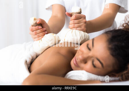 Woman having herb compress massage in beauty spa Stock Photo