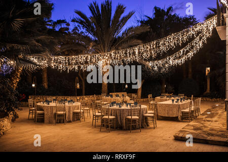 Outdoors restaurant with served tables prepared for dining in the evening Stock Photo