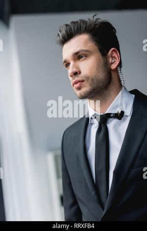 thoughtful bodyguard in suit with earphone Stock Photo