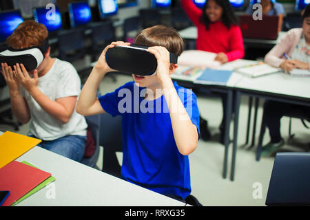 Junior high school boy students using virtual reality simulators in classroom Stock Photo