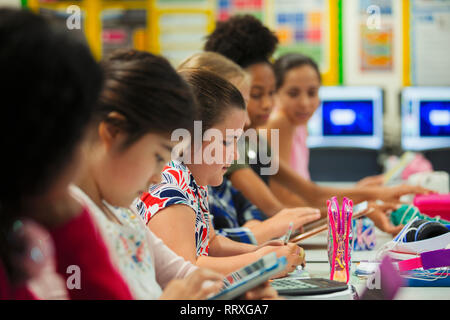 Junior high school girl students studying at desk in classroom Stock Photo