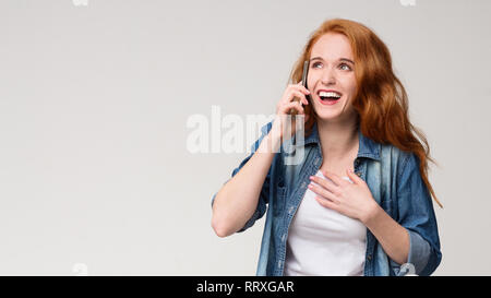 Young amazed redhead woman talking on phone, Stock Photo