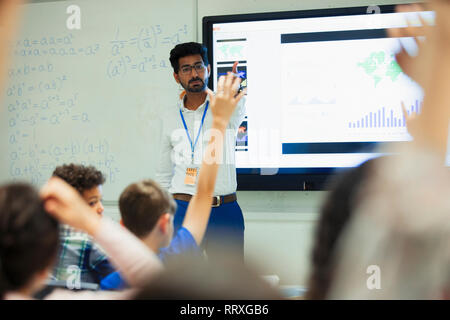 Teacher leading lesson, calling on students in classroom Stock Photo