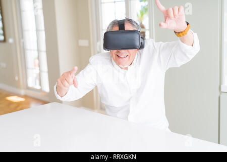 Man wearing virtual reality glasses smiling looking very happy and excited Stock Photo