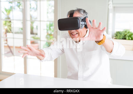 Man wearing virtual reality glasses smiling looking very happy and excited Stock Photo