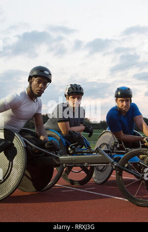 Portrait confident, determined paraplegic athletes training for wheelchair race on sports track Stock Photo