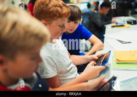Junior high school boys using digital tablet in classroom Stock Photo