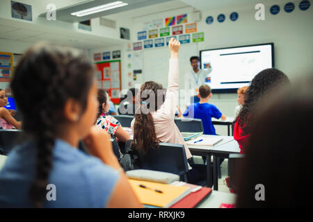 Junior high school student raising hand, asking a question during lesson in classroom Stock Photo