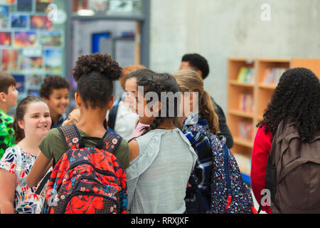 Junior high girl students talking in library Stock Photo