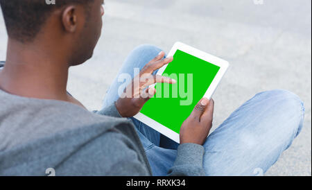 Young man using digital tablet pc with gree screen Stock Photo