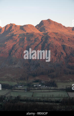 First light on Harrisons Stickle, one of the Langdale Pikes, seen over The Old Dungeon Ghyll Hotel, Lake District, UK Stock Photo