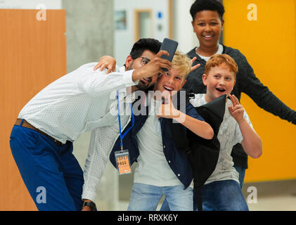 Junior high boy students and male teacher taking selfie with smart phone Stock Photo