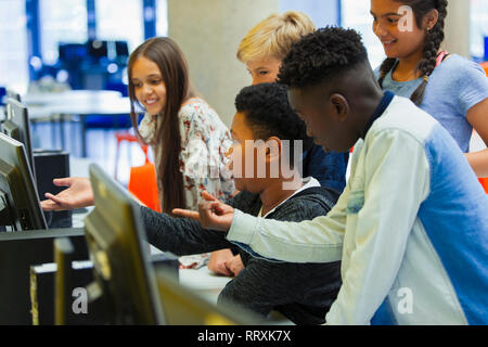 Junior high students using computer in library Stock Photo