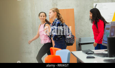 Junior high girl students walking in library Stock Photo