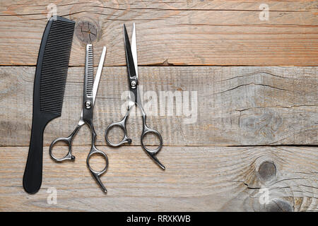 Comb and vintage hairdressing scissors on wooden background Stock Photo