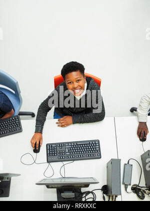 Portrait from above confident junior high boy student using computer in computer lab Stock Photo