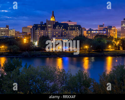 Saskatoon skyline at night along the Saskatchewan River and valley. Saskatchewan is a prairie province in the country of Canada and is rural. Stock Photo