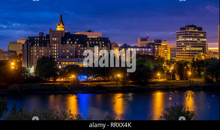 Saskatoon skyline at night along the Saskatchewan River and valley. Saskatchewan is a prairie province in the country of Canada and is rural. Stock Photo