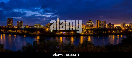 Saskatoon skyline at night along the Saskatchewan River and valley. Saskatchewan is a prairie province in the country of Canada and is rural. Stock Photo