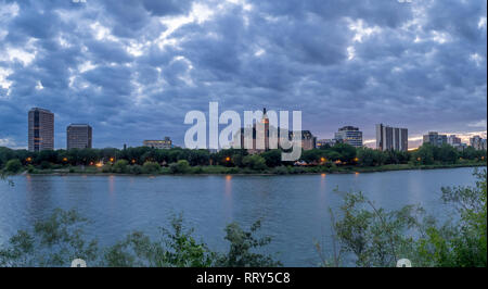 Saskatoon skyline at night along the Saskatchewan River. The Saskatchewan River valley is a popular walking destination in this Canadian prairie city. Stock Photo