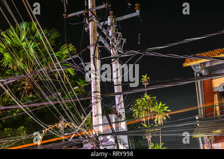 Night street view of bunch of wires connected on the pillars in Bali island Stock Photo