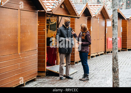 STRASBOURG, FRANCE - DEC 11, 2018: Journalist taking interview to Christmas Market seller after terrorist attack in Place Kleber Stock Photo