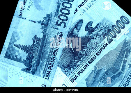 Several Indonesian rupiah banknotes close up. Blue color toned Stock Photo