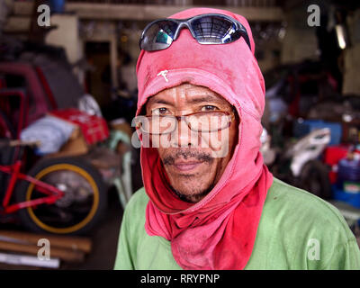 ANTIPOLO CITY, PHILIPPINES - FEBRUARY 21, 2019: A carpenter wearing a shirt on his head as protective gear poses for the camera. Stock Photo