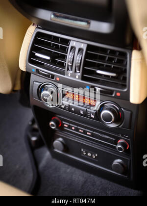 Modern car climate control panel for passengers in rear row with shallow depth of field. Four zone climate control. Car interior detail. Back passenge Stock Photo