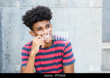 Laughing african american young adult man outdoors in the summer Stock Photo