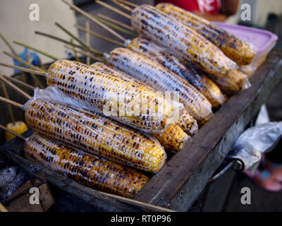 Close up photo of grilled sweet corn on barbecue stick sold at a street food cart Stock Photo