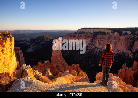 Woman enjoying the Beautiful View of an American landscape during a sunny sunset. Taken in Bryce Canyon National Park, Utah, United States of America.