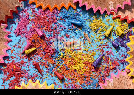 Colored lead and pencil shavings on blue background. Stock Photo