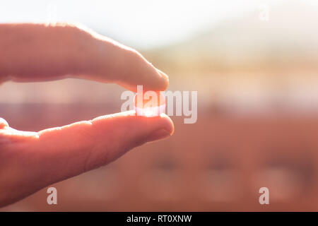 Water gel balls. Small gel ball in the hand at sunrise. Polymer gel. Silica gel. Balls of hydrogel. Crystal liquid ball with reflection. Texture backg Stock Photo