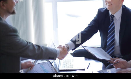handshake of senior business partners on the Desk Stock Photo
