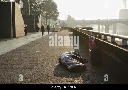 Glasgow, UK, 27th February 2019 : Homeless person sleeping rough for a number of nights now under the South Portland Suspension Bridge,with commuters walking past every morning. Credit: Pawel Pietraszewski / Alamy Live News