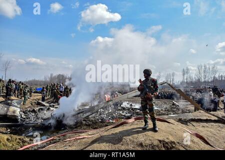 Budgam, Kashmir. 27th February, 2019. An Indian army man stands guard near the wreckage of an Indian military aircraft which crashed in Budgam, 20kms from Srinagar, Kashmir. An Indian Air Force aircraft crashed on Wednesday in Budgam district of Kashmir, killing seven persons including six Indian Air Force personnel and one civilian. The aircraft crashed due to technical reasons, officials said. Credit: Saqib Majeed/SOPA Images/ZUMA Wire/Alamy Live News Stock Photo