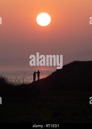Pembrokeshire, Wales, UK. 27th February, 2019. Last day on the waves as the sun sets and hot weather ends at Manorbier Beach, Pembrokeshire West Wales UK Wednesay 27th February 2019 Credit: dayslikethis/Alamy Live News Stock Photo