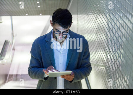 Young businessman standing on stairs using digital tablet Stock Photo