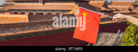 Enjoying vacation in China. Young woman with national chinese flag in Forbidden City. Travel to China concept. Visa free transit 72 hours, 144 hours Stock Photo