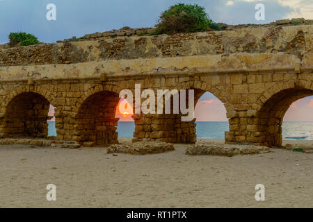 Sunset view of the beach and the Roman Aqueduct in Caesarea, Northern Israel. Its and ancient water supply system Stock Photo